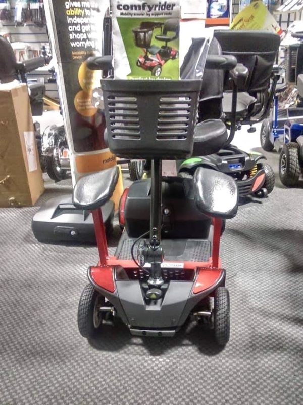 A red four wheeled mobility scooter with two matching Comfyrider leg rests. 