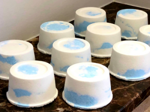 Rows of blue and white marbled bath bombs on a counter top.